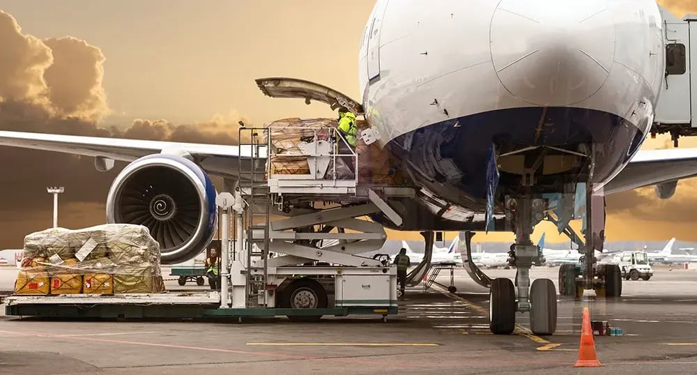 Close-up detail view of cargo cart trolley full with commercial parcels against turboprop cargo plane